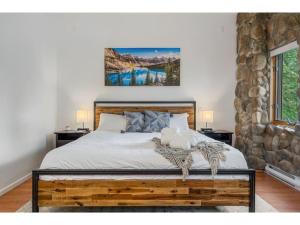 a bedroom with a wooden bed with two night stands at Chardonnay Chalet I Fireplace I Mountain View I TV in Invermere