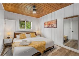 ein Schlafzimmer mit einem großen Bett und einer gelben Decke in der Unterkunft Merlot Mountain I Ping Pong I Sleep 7 I 55 RokuTV in Invermere