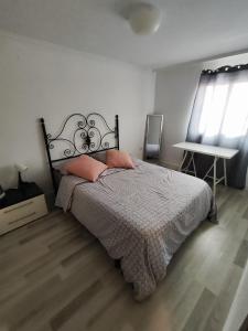 a bedroom with a bed and a table and a window at Alojamiento cerca de la Playa in Valencia