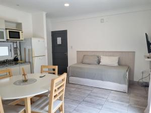 ein Schlafzimmer mit einem Bett und einem Tisch sowie eine Küche in der Unterkunft Excelente Departamento con patio in Salta