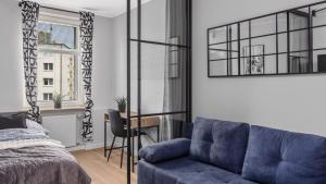 sypialnia z niebieską kanapą i łóżkiem w obiekcie Unique Apartments - Apartamenty w Centrum - Śląska 55 w mieście Gdynia