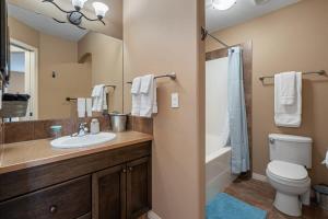a bathroom with a sink and a toilet and a mirror at Prairie Oasis I Sleeps 16 l BBQ & Patio l Smart TV in Sylvan Lake +45 photos