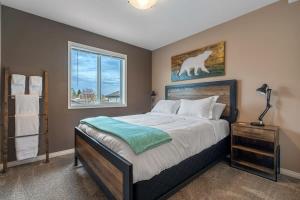 a bedroom with a large bed and a window at Prairie Oasis I Sleeps 16 l BBQ & Patio l Smart TV in Sylvan Lake