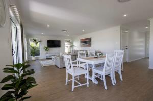 una sala da pranzo con tavolo bianco e sedie bianche di The Hideaway - Close to Zoo & Golf Club a Dubbo