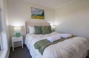 um quarto com uma cama com duas almofadas em The Hideaway - Close to Zoo & Golf Club em Dubbo