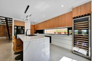eine Küche mit einer weißen Theke und Holzwänden in der Unterkunft Grand Stirling - Elite Escape, Unparalleled Luxury in Orange