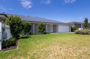 a house with a fence and a yard at The Hideaway - Close to Zoo & Golf Club in Dubbo