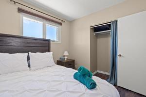 - une chambre avec un grand lit blanc et une fenêtre dans l'établissement Bahama Breeze I Hot Tub I Pool I 5 Bedroom, à Drumheller