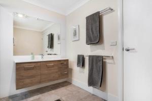 a bathroom with a sink and a mirror at Crooked Lane Apartment - CBD, Stylish & Central in Wagga Wagga +13 photos