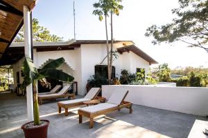 een patio met ligstoelen en een huis bij Cocoon CoLive Nosara in Nosara