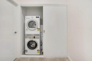 a laundry room with a washer and dryer in it at Crooked Lane Apartment - CBD, Stylish & Central in Wagga Wagga
