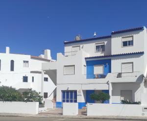un edificio de apartamentos blanco con detalles azules en Casa Furt@do, en Burgau