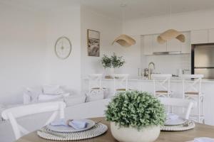 a white living room with a couch and a table at Macquarie - Sleek & Stylish, Countryside Views in Dubbo