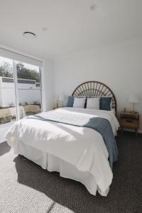 a white bedroom with a large bed and a window at Macquarie - Sleek & Stylish, Countryside Views in Dubbo