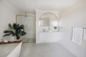 a white bathroom with a sink and a mirror at Macquarie - Sleek & Stylish, Countryside Views in Dubbo