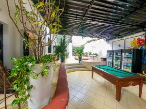 a pool table in a room with potted plants at Hotel Filha do Cacique in Belém