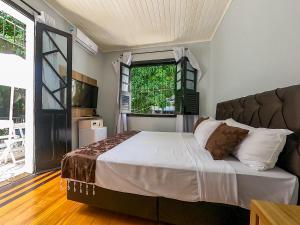 Hotel Filha do Cacique في بيليم: غرفة نوم بسرير ونافذة كبيرة