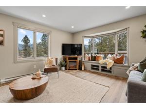 a living room with a couch and a coffee table at Evergreen Escape I Fireplace I Walk to the Lake in Invermere