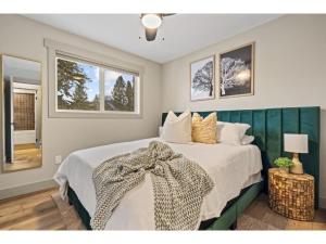 a bedroom with a large bed and two windows at Evergreen Escape I Fireplace I Walk to the Lake in Invermere
