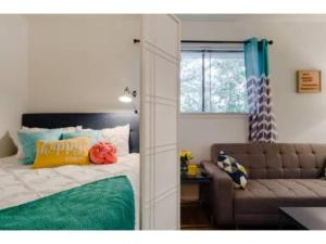 - une chambre avec un lit, un canapé et une fenêtre dans l'établissement Nomad Studio l 12-Min to DT l 5-Min to Domain l TV, à Austin