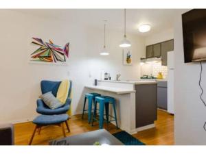 - une cuisine avec des chaises bleues et un comptoir dans une pièce dans l'établissement Nomad Studio l 12-Min to DT l 5-Min to Domain l TV, à Austin