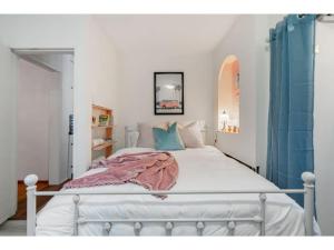 1 dormitorio con cama blanca y almohadas azules en Betty Lou's Library l Cozy Reading Nook l 55 Roku en Cranbrook