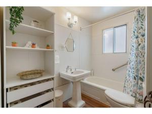 a bathroom with a sink and a toilet and a tub at Betty Lou's Library l Cozy Reading Nook l 55 Roku in Cranbrook