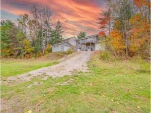 ein Haus auf einer unbefestigten Straße auf einem Feld in der Unterkunft The Artistry I Sled In & Sled Out I Riverside I TV in Bancroft