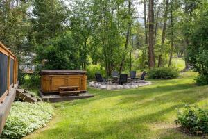 a backyard with a grill and chairs and trees at The Matterhorn I HotTub I Ping Pong I Chalk Wall in Fairmont Hot Springs