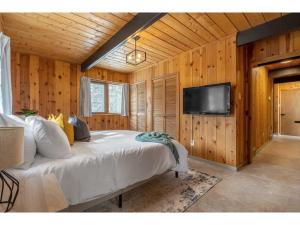 a bedroom with a bed and a flat screen tv at The Matterhorn I HotTub I Ping Pong I Chalk Wall in Fairmont Hot Springs