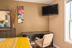 a bedroom with a desk and a tv on the wall at Point Of View I 55 SmartTV I Riverside I Sleeps 5 in Bancroft