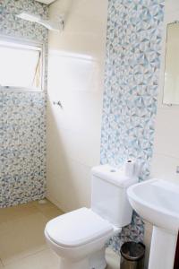 a bathroom with a toilet and a sink at GM Hotel SP in Utinga