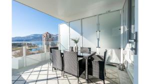 a dining room with a table and chairs on a balcony at The Luna l No Service Fees l Pool l HotTub in Kelowna