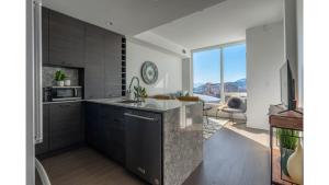 a kitchen with a sink and a large window at The Luna l No Service Fees l Pool l HotTub in Kelowna