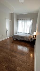 een slaapkamer met een bed voor een raam bij luxurious big house in Jersey City