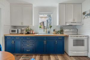 a kitchen with blue cabinets and a sink at Drum Cottage I Central I Big Dino I Fire Pit I BBQ in Drumheller