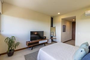 a bedroom with a bed and a flat screen tv at Stunning Ocean View Penthouse With Private Pool - B301 in Holbox Island