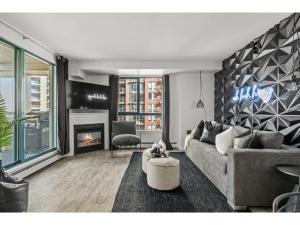 a living room with a couch and a fireplace at The Loki I Patio & BBQ I Sleeps 5 I Downtown I TV in Calgary
