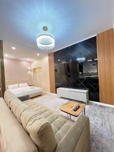 sala de estar con sofá grande y cama en Comfort City 2-nd, en Almaty
