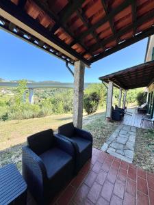 patio con 2 sedie sotto un pergolato di Quinta do Casarão by VinteOito - Casa de Campo com Piscina ad Amarante