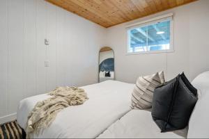 ein Schlafzimmer mit einem weißen Bett und einem Fenster in der Unterkunft Blue Lagoon | No Service Fees | BBQ & Firepit in Invermere