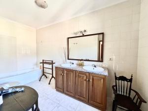 La salle de bains est pourvue de 2 lavabos et d'un miroir. dans l'établissement Quinta do Casarão by VinteOito - Casa de Campo com Piscina, à Amarante