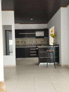 a kitchen with black cabinets and a table and a chair at NIRVANA APARTAESTUDIOS in Arauca