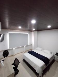a bedroom with a large bed and a desk at NIRVANA APARTAESTUDIOS in Arauca