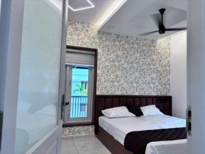a bedroom with a bed and a window at Nishwas Homes in Ernakulam