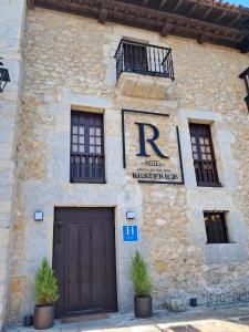 a stone building with a door and two windows at Hotel BESTPRICE Santillana in Santillana del Mar