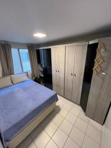 a bedroom with a blue bed in a room at AP Condomínio Fechado in São José dos Pinhais
