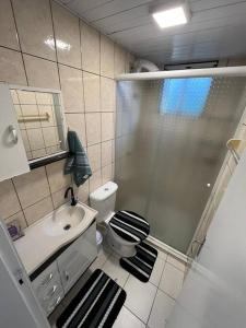 a bathroom with a shower and a toilet and a sink at AP Condomínio Fechado in São José dos Pinhais