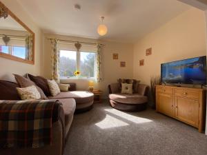 uma sala de estar com um sofá e uma televisão de ecrã plano em Treetops - Bright 2 Bed Flat - Super Location em Inverness
