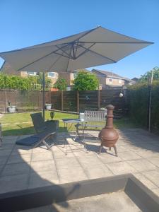a patio with a table and chairs and an umbrella at Eskdale Durham DH1 in Durham